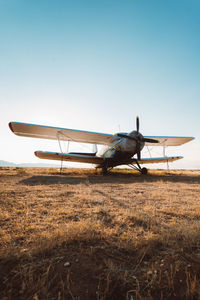 Airplane on field against clear sky