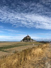 Temple by landscape against sky