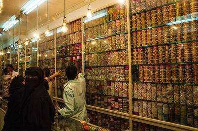 Rear view of people photographing illuminated building