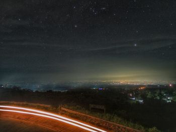 Aerial view of illuminated road against sky at night