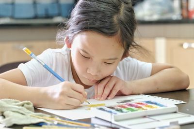 Close-up of girl making face on table