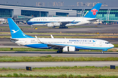 Airplane on airport runway against sky