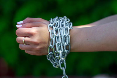 Cropped hands of woman tied with chain