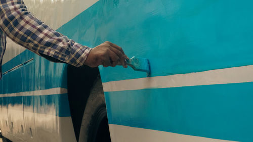 Labor painting a bus with color