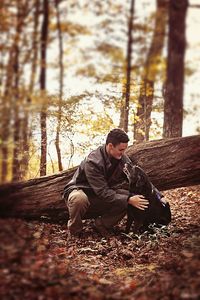 Young man sitting in forest