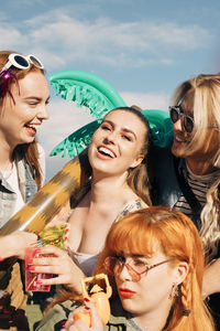 Portrait of playful friends enjoying at music festival during sunny day