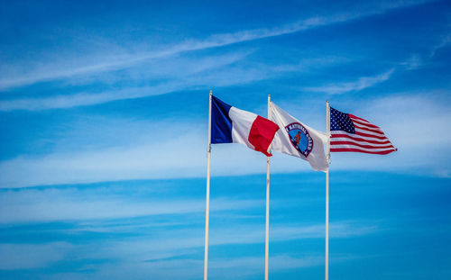 Low angle view of flag flags against blue sky