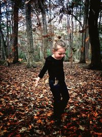Full length of a girl playing in autumn leaves