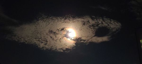 Low angle view of illuminated lights against sky at night