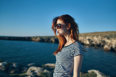 Young woman wearing sunglasses against sky