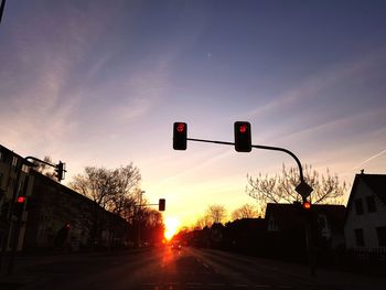 Road signal against sky during sunset