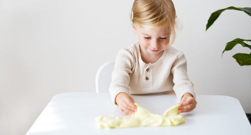 High angle view of girl playing with sand on table