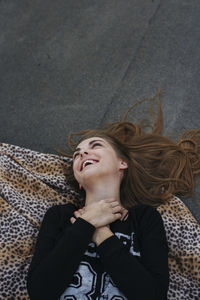 Happy woman laughs lying on her back