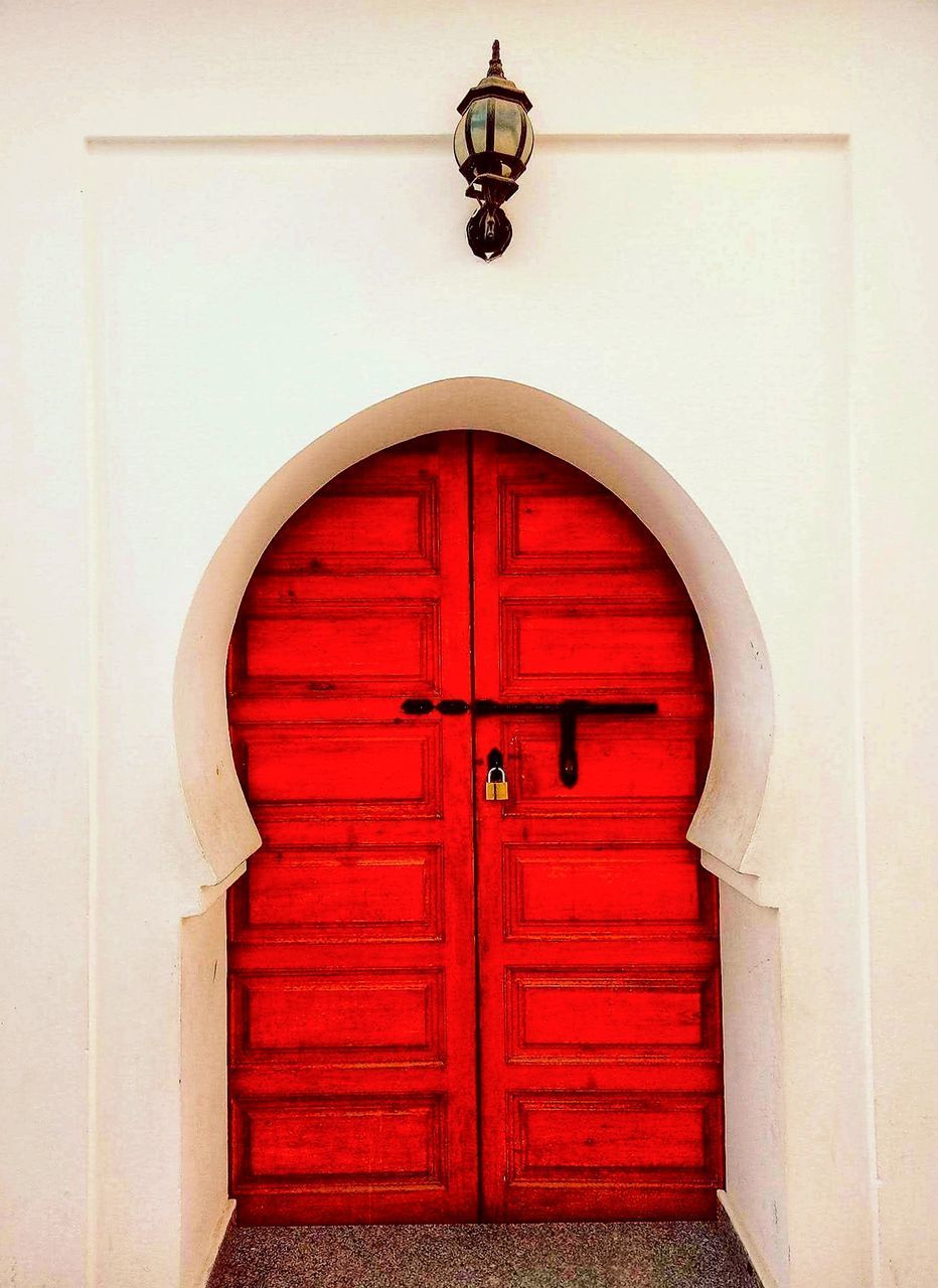 CLOSED DOOR OF RED BUILDING WITH OPEN DOORS