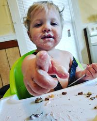 Portrait of girl holding food on table