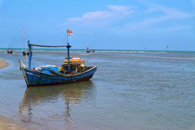 Boat moored in sea against sky