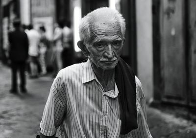 Portrait of senior man walking on street in city