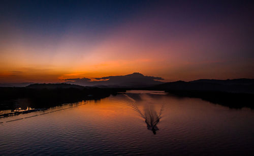 Scenic view of lake against romantic sky at sunset