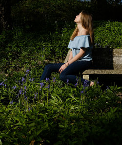 Close-up of teenage girl sitting on bench outdoors