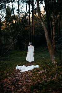 Rear view of woman with umbrella in forest