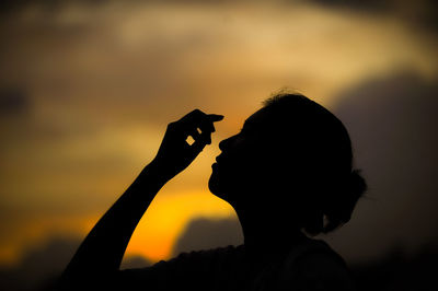Portrait of silhouette man holding orange sky during sunset