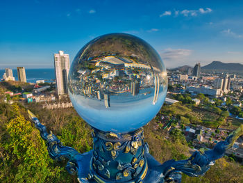 Photos of a king of nagas statue and big crystal ball view reflection of the sriracha city.