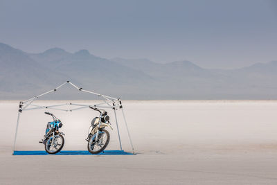 Bicycle on desert against sky