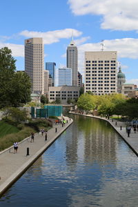 River amidst buildings in city against sky