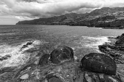 Scenic view of sea and mountains against sky