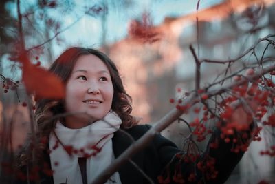 Portrait of smiling young woman against plants