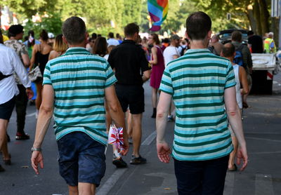 Rear view of people walking on city street