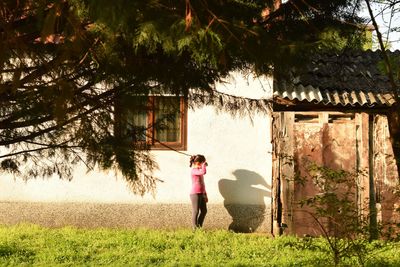 Full length of woman standing by tree