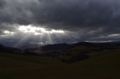 Scenic view of landscape against storm clouds at night