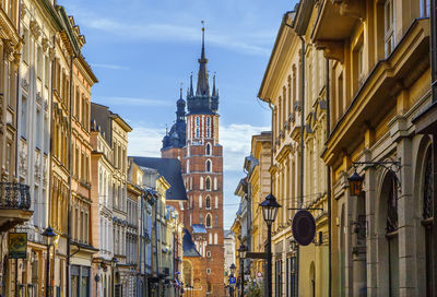 Street with historical houses and view of st. mary's basilica in krakow old town, poland