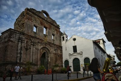 People in historic building against sky