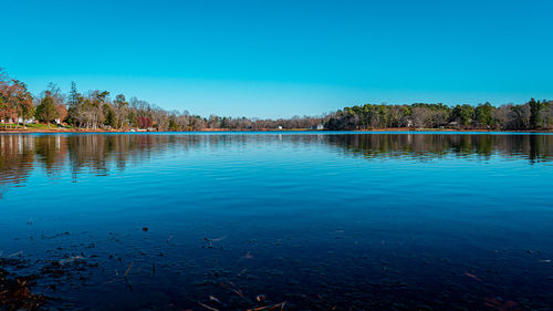 Scenic view of lake against clear blue sky