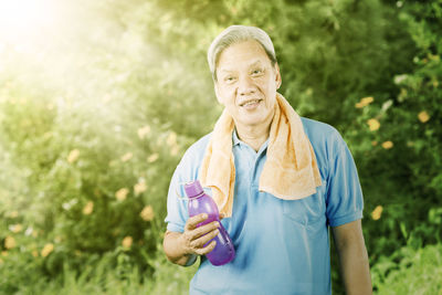 Portrait of smiling man holding plant