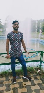 Full length portrait of young man standing in rain