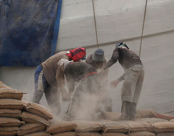 Workers with cement dust at construction site