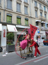 People on road against buildings in city