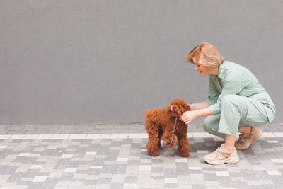 Rear view of woman with dog against sky