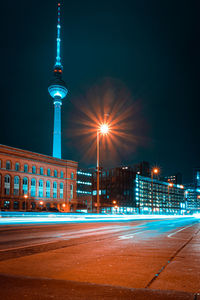 Light trails on street against buildings at night