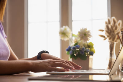 Low section of woman standing on table at home