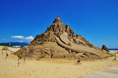 View of sand dunes against clear blue sky