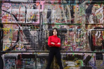 Portrait of a teenage boy standing against graffiti