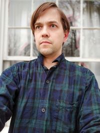 Portrait of man with worried or concerned expression in front of window