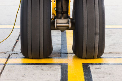 Nose wheel of airplane on yellow airport markings 