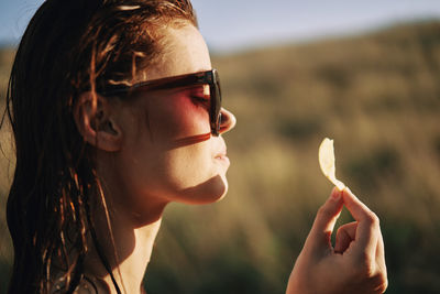 Close-up portrait of young woman wearing sunglasses