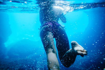 Low section of man swimming in sea