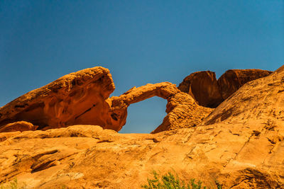 Low angle view of rock formation against clear blue sky